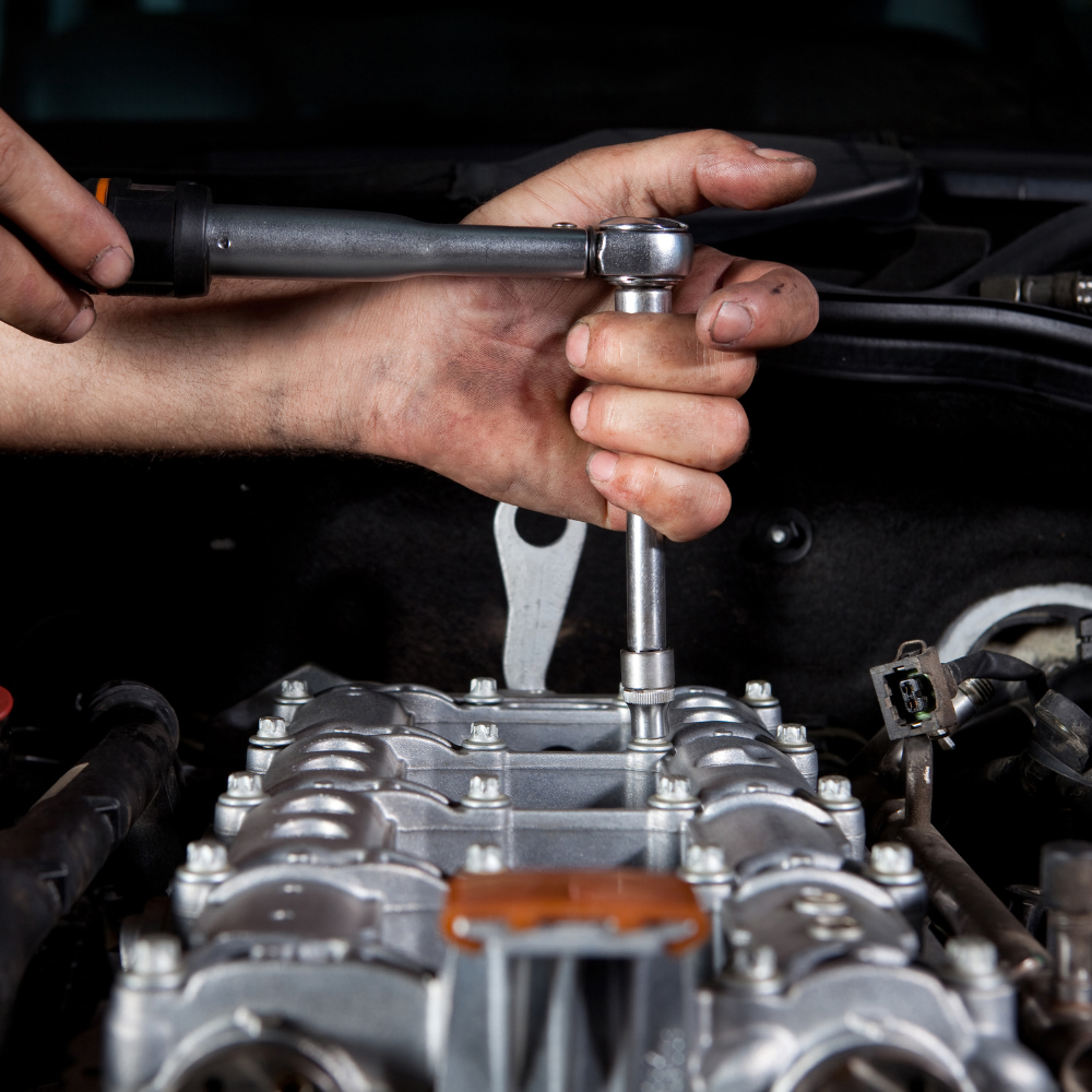 Close up of hands working on car engine