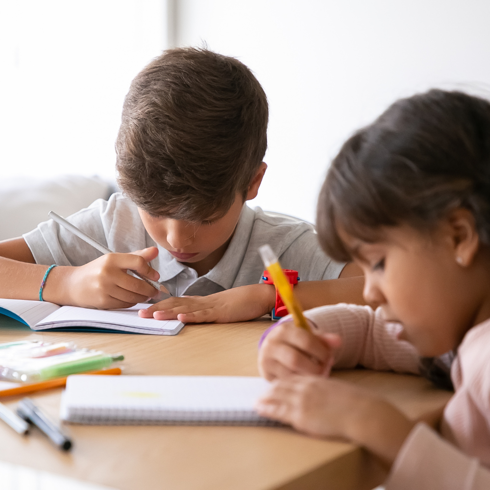 Two kids doing homework at a table